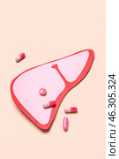 Pink paper liver with pills on beige background. Стоковое фото, фотограф Pixel_shot / Фотобанк Лори