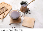 Drink coasters with cup of coffee and jezve on grey grunge table. Стоковое фото, фотограф Pixel_shot / Фотобанк Лори