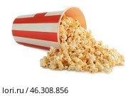 Overturned cup with tasty popcorn on white background. Стоковое фото, фотограф Pixel_shot / Фотобанк Лори