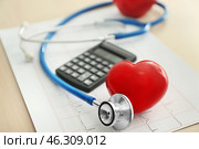 Stethoscope with heart, calculator and cardiogram on table. Стоковое фото, фотограф Pixel_shot / Фотобанк Лори