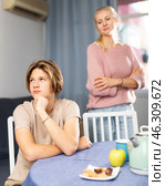 Offended teenager sitting at home table after disagreements with mom. Стоковое фото, фотограф Яков Филимонов / Фотобанк Лори