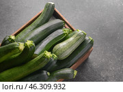 Wooden crate with ripe zucchinis on dark table. Стоковое фото, фотограф Pixel_shot / Фотобанк Лори