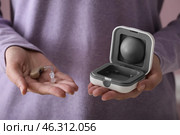 Woman with hearing aid and box, closeup. Стоковое фото, фотограф Pixel_shot / Фотобанк Лори