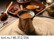 Cezve with coffee in sand on dark background. Стоковое фото, фотограф Pixel_shot / Фотобанк Лори