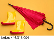 Stylish umbrella and gumboots on color background. Стоковое фото, фотограф Pixel_shot / Фотобанк Лори