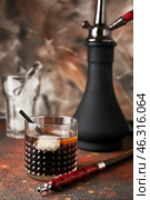 Glass of cold whiskey with hookah on table. Стоковое фото, фотограф Pixel_shot / Фотобанк Лори