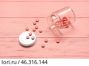 Bottle with hormonal pills on pink wooden background. Стоковое фото, фотограф Pixel_shot / Фотобанк Лори