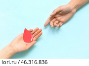 Women with paper blood drop on blue background. World Donor Day. Стоковое фото, фотограф Pixel_shot / Фотобанк Лори