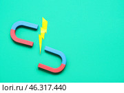 Paper lightning with horseshoe shaped magnet on green background. Стоковое фото, фотограф Pixel_shot / Фотобанк Лори