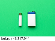 Alkaline batteries on green background, top view. Стоковое фото, фотограф Pixel_shot / Фотобанк Лори