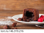 Plate with tasty lava cake fondant and raspberry on wooden background, closeup. Стоковое фото, фотограф Pixel_shot / Фотобанк Лори