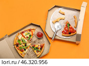 Cardboard boxes with tasty pizza and leftovers on color background. Стоковое фото, фотограф Pixel_shot / Фотобанк Лори