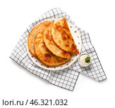 Plate with tasty chebureks, sauce and kitchen towel on white background. Стоковое фото, фотограф Pixel_shot / Фотобанк Лори