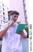 Young Man Multitasking with Smartphone and Tablet Outdoors.Vertical. Стоковое видео, видеограф Raquel Corcoles Mendez / Фотобанк Лори