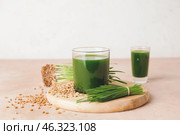 Glass with fresh wheatgrass juice on light background. Стоковое фото, фотограф Pixel_shot / Фотобанк Лори