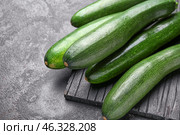 Board with fresh zucchini squashes on dark background. Стоковое фото, фотограф Pixel_shot / Фотобанк Лори