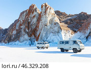 LAKE BAIKAL, OLKHON ISLAND, IRKUTSK REGION, RUSSIA -  February 22, 2025: Tourists arrived to famous rocks of Cape Sagan-Khushun in traditional UAZ off-road vehicle on sunny winter day. Редакционное фото, фотограф Виктория Катьянова / Фотобанк Лори