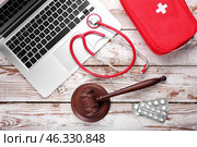 Judge gavel, pills, laptop, first aid kit and stethoscope on wooden background. Concept of health care reform. Стоковое фото, фотограф Pixel_shot / Фотобанк Лори