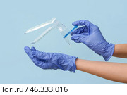 Doctor hands in medical gloves with gynecological speculum on blue background. Стоковое фото, фотограф Pixel_shot / Фотобанк Лори