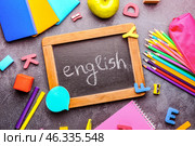 Chalkboard with text ENGLISH and stationery on dark background. Стоковое фото, фотограф Pixel_shot / Фотобанк Лори
