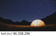 Illuminated tent under starry night sky in mountain valley. Стоковое видео, видеограф Данил Руденко / Фотобанк Лори
