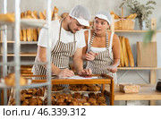 Man and woman sellers in bakery make calculations, work with paper documents and count using phone. Стоковое фото, фотограф Яков Филимонов / Фотобанк Лори