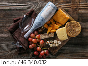 Assortment of tasty cheese with bottle of wine on table. Стоковое фото, фотограф Pixel_shot / Фотобанк Лори