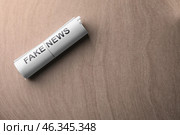 Roll of papers with phrase FAKE NEWS on table. Стоковое фото, фотограф Pixel_shot / Фотобанк Лори