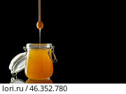 Jar and dipper with tasty honey on dark background. Стоковое фото, фотограф Pixel_shot / Фотобанк Лори