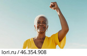 Black mature woman outdoors with raised fist of empowerment, strength and women solidarity, International Womens Day, Black History Month concept. Стоковое AI-изображение, AI-художник Анастасия Золотницкая / Фотобанк Лори