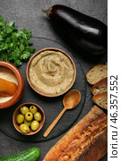 Bowl with tasty baba ghanoush and fresh ingredients on dark background. Стоковое фото, фотограф Pixel_shot / Фотобанк Лори