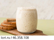 Glass jar with fresh sourdough and bread slices on table. Стоковое фото, фотограф Pixel_shot / Фотобанк Лори