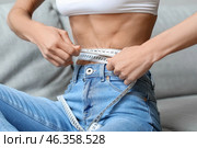Young woman with anorexia measuring her waist at home. Стоковое фото, фотограф Pixel_shot / Фотобанк Лори