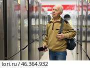 Senor man pensioner buying fridge in showroom of electrical appliance store. Стоковое фото, фотограф Татьяна Яцевич / Фотобанк Лори