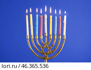 Menorah with burning candles for Hannukah celebration on blue background, closeup. Стоковое фото, фотограф Pixel_shot / Фотобанк Лори
