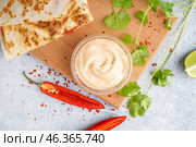 Wooden board with bowl of tasty chipotle sauce on light background. Стоковое фото, фотограф Pixel_shot / Фотобанк Лори