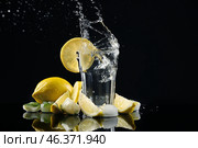 Glass of fresh lemonade with splashes on dark background. Стоковое фото, фотограф Pixel_shot / Фотобанк Лори