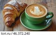 Green ceramic cup of frothy cappuccino coffee with croissants on rustic wood background. Hot latte with art milk foam and freshly-baked Brioche on cafe table. Breakfast or coffee break. Morning ritual. Стоковое AI-видео, аниматор Марина Демидюк / Фотобанк Лори