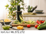 Spiralizer with zucchini noodles and vegetables on kitchen table. Стоковое фото, фотограф Pixel_shot / Фотобанк Лори