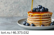 Homemade Pancakes stack with blueberries and honey on a modern ceramic plate. Classic blueberry pancake stack filled with syrup among gray concrete wall background. Sweet breakfast with berry, fruit. Стоковое AI-видео, аниматор Марина Демидюк / Фотобанк Лори