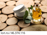 Bottle of eucalyptus essential oil and jar with cream on wooden background. Стоковое фото, фотограф Pixel_shot / Фотобанк Лори