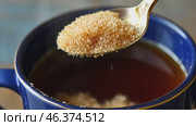 Person adding cane sugar with a spoon to cup of fresh aromatic coffee. Close up of teaspoon putting brown sugar into hot steamed drink mug. Sugar Being Poured into Cup of Coffee Americano, Close-Up. Стоковое AI-видео, аниматор Марина Демидюк / Фотобанк Лори