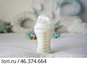 Feeding bottle of baby formula on bed. Стоковое фото, фотограф Pixel_shot / Фотобанк Лори