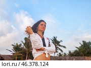 A woman stands confidently on a picturesque Sri Lankan beach, with palm trees swaying gently in the background. Стоковое фото, фотограф Aleksandr Golubev / Фотобанк Лори