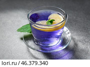 Glass cup of organic butterfly tea and lemon on grey background, closeup. Стоковое фото, фотограф Pixel_shot / Фотобанк Лори