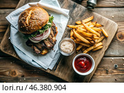 French fries, burger, pork ribs on a stylish board on a wooden background. Fried potatoes. The concept of fast food, junk food and fast food preparation. Стоковое AI-изображение, AI-художник Photojuli / Фотобанк Лори