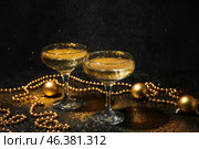 Glasses of champagne with glitters and Christmas decorations on dark background. Стоковое фото, фотограф Pixel_shot / Фотобанк Лори