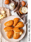 Plate of tasty sochniki with cottage cheese and ingredients on white wooden background. Стоковое фото, фотограф Pixel_shot / Фотобанк Лори
