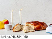 Traditional challah bread with glowing candles on light background. Shabbat Shalom. Стоковое фото, фотограф Pixel_shot / Фотобанк Лори