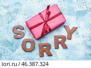 Gift with word SORRY on color background. Стоковое фото, фотограф Pixel_shot / Фотобанк Лори